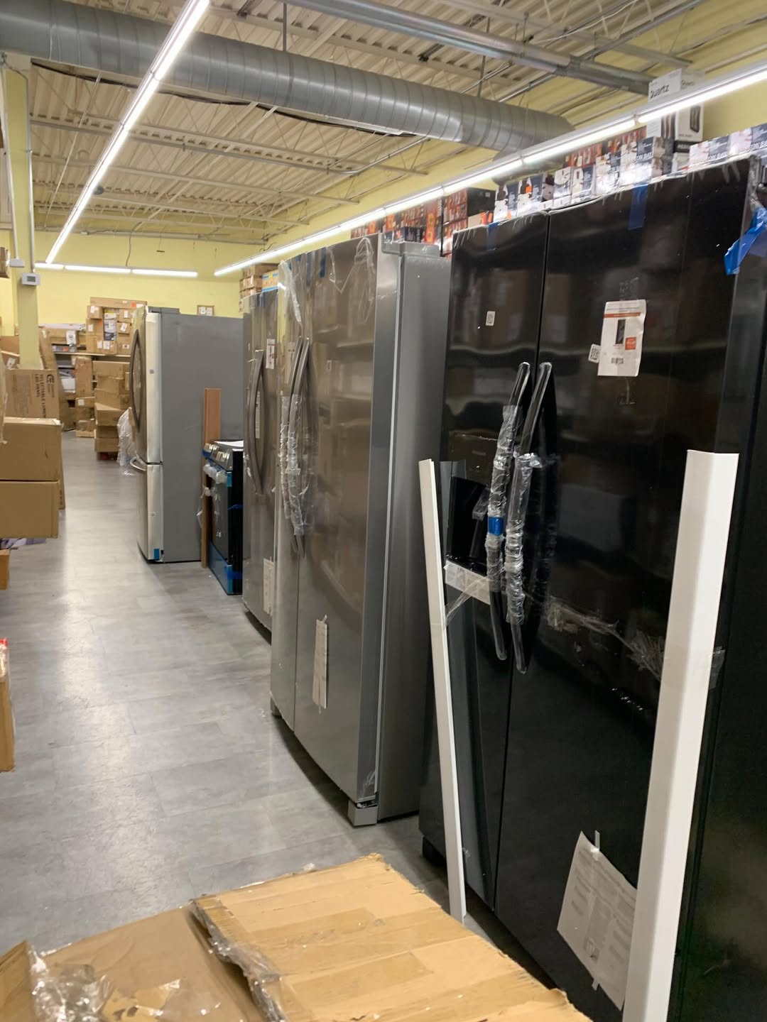 Warehouse aisle stocked with rows of major appliances ready for wholesale