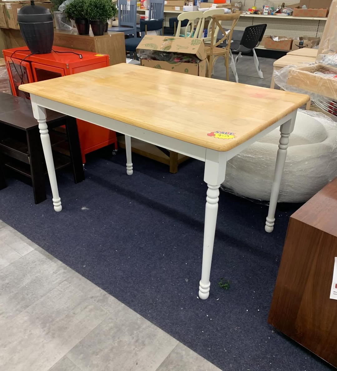 Farmhouse dining table with upholstered side chairs on the showroom floor