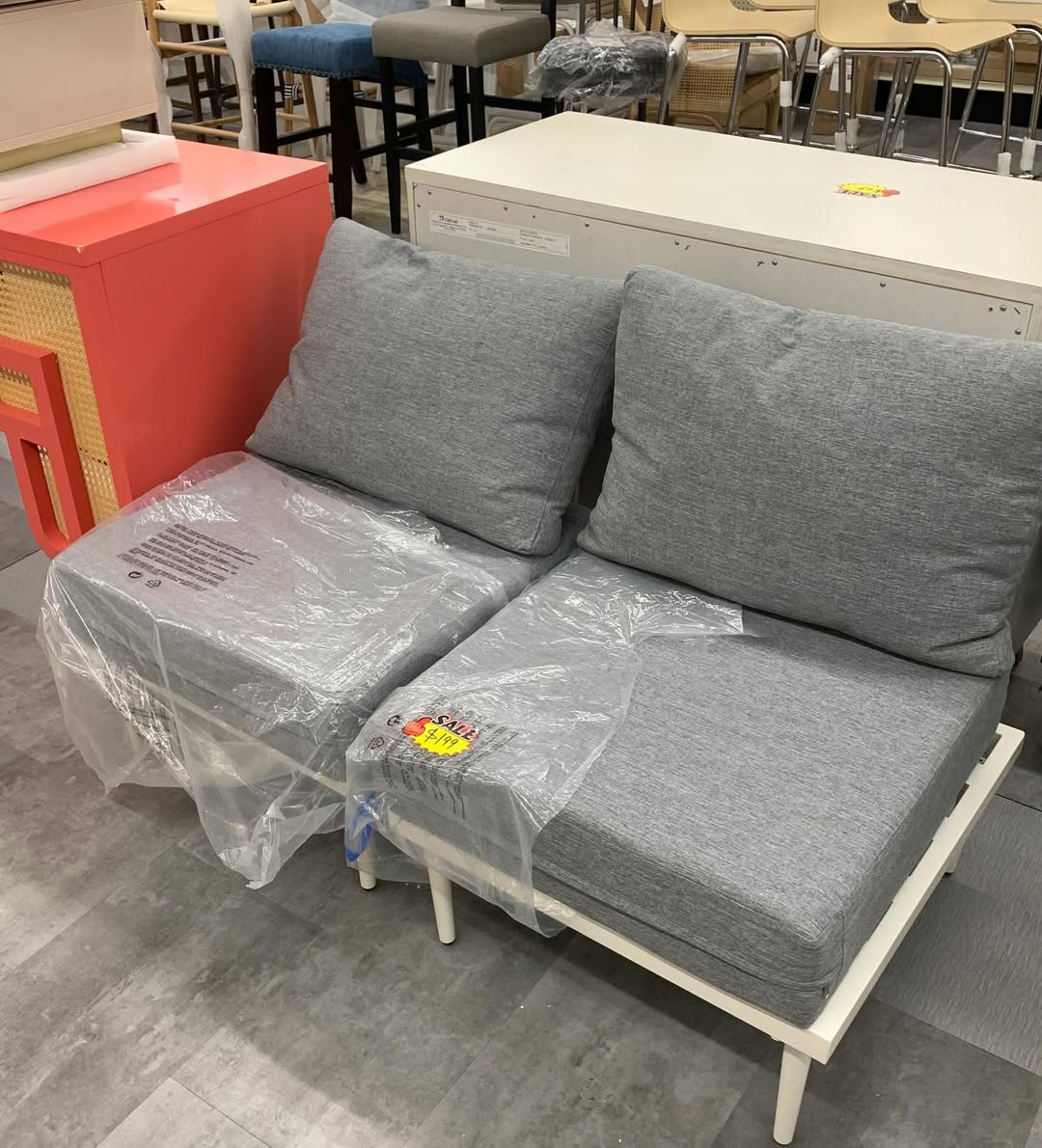 Grey upholstered loveseat on the ABC Home Outlet floor