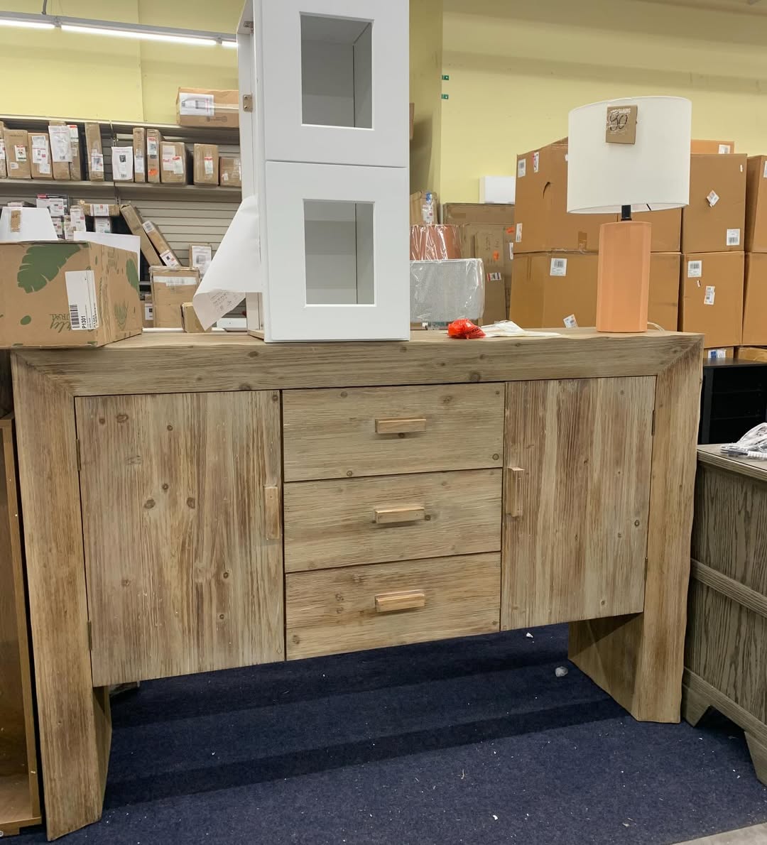 Wooden sideboard with table lamp on top